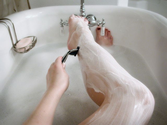 Девушка бреет ноги